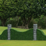Arched turf hunter jump wall with stone pillar standards